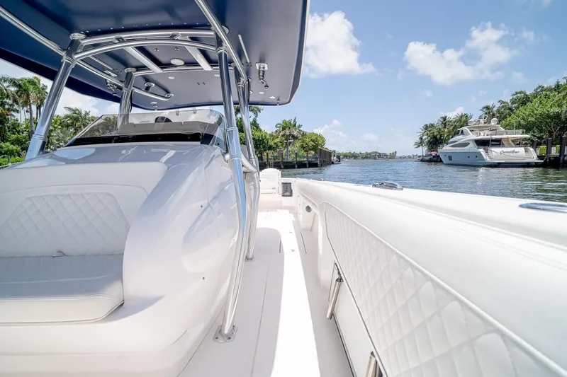 Slide: The Image of 2021 Intrepid 400 Center Console boat on a sunny waterway, featuring sleek design and luxury seating. - 33