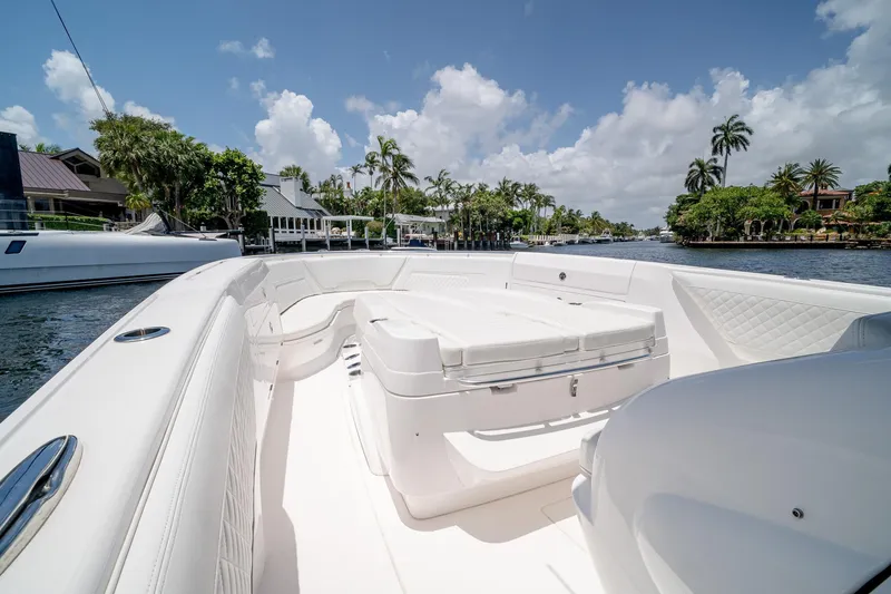 Slide: The Image of 2021 Intrepid 400 Center Console boat on a sunny waterway, surrounded by lush greenery. - 34