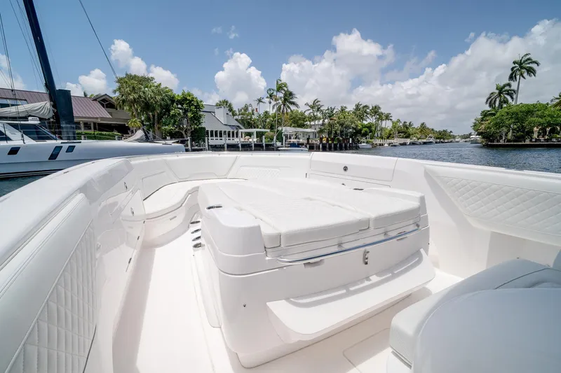 Slide: The Image of 2021 Intrepid 400 Center Console boat with spacious seating, docked by a scenic waterfront. - 35