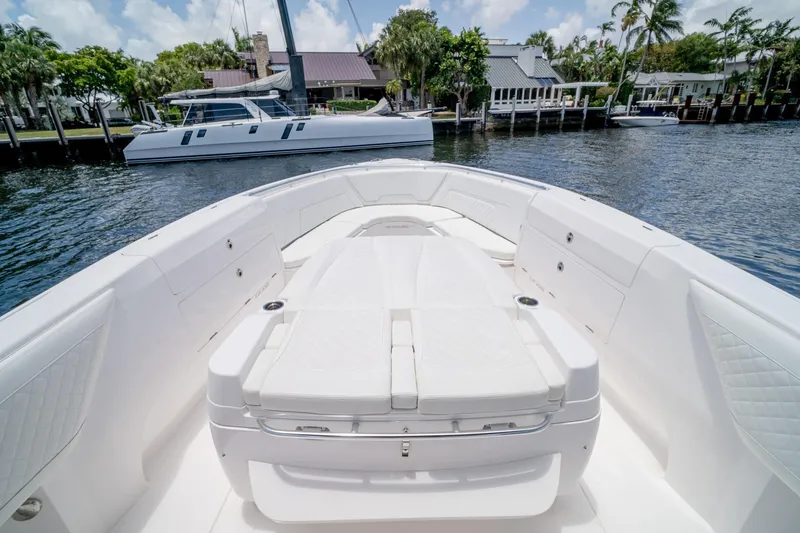 Slide: The Image of 2021 Intrepid 400 Center Console boat with spacious seating, docked near waterfront homes. - 37