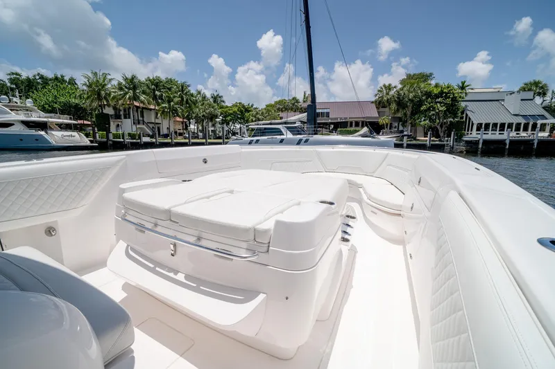 Slide: The Image of 2021 Intrepid 400 Center Console boat with luxurious white seating, docked near waterfront homes. - 38