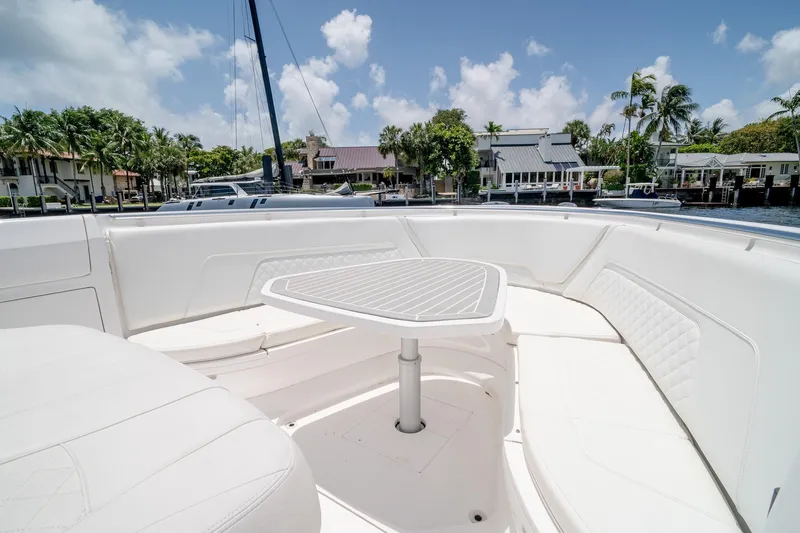 Slide: The Image of 2021 Intrepid 400 Center Console boat with white seating and table, docked near waterfront homes. - 41