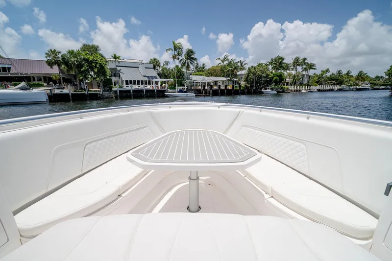 Slide: The Image of 2021 Intrepid 400 Center Console boat with seating and table, docked by waterfront homes. - 42