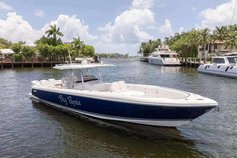 Slide: The Image of 2021 Intrepid 400 Center Console boat on a sunny waterway, surrounded by yachts and palm trees. - 7