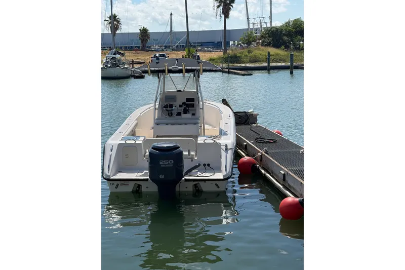 Slide: The Image of 2008 Pursuit C 230 Center Console boat docked in a marina, rear view. - 52