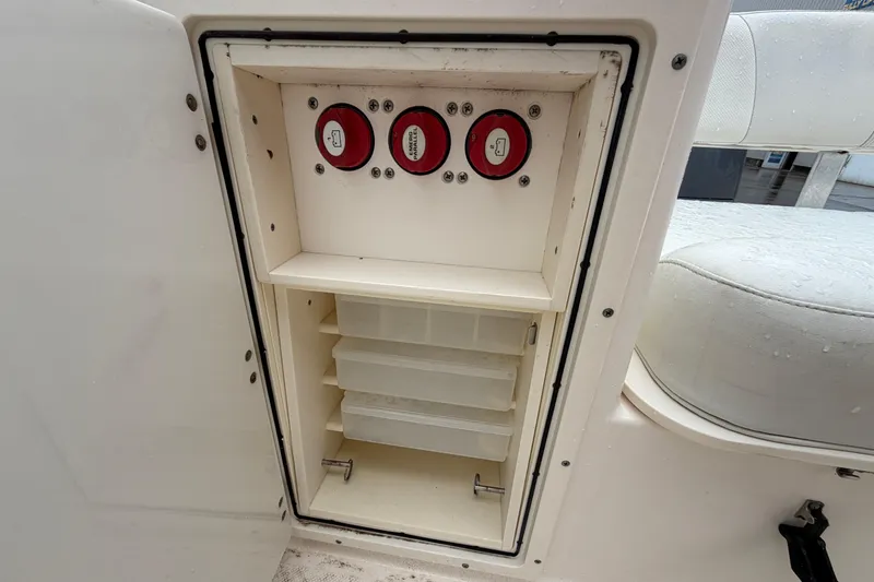 Slide: The Image of Storage compartment with switches on a 2008 Pursuit C 230 Center Console boat. - 22