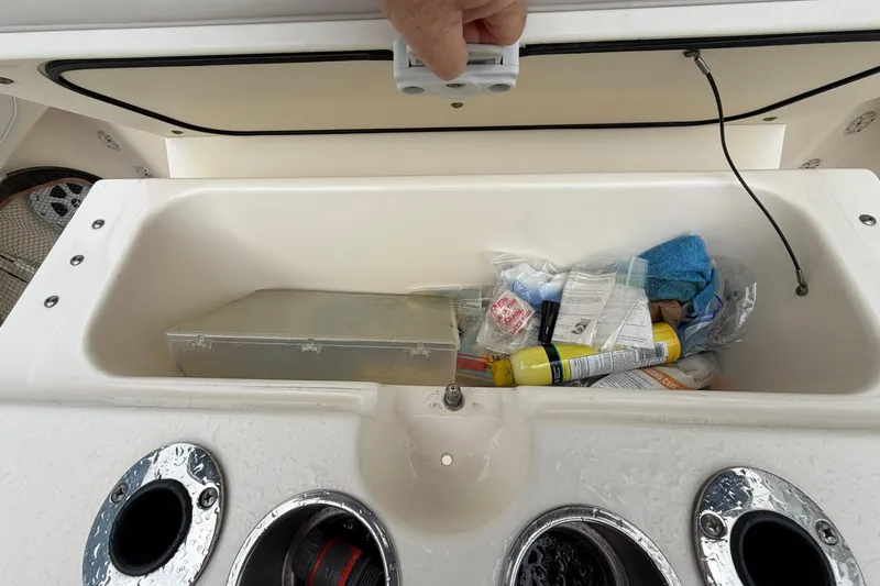 Slide: The Image of Storage compartment on a 2008 Pursuit C 230 Center Console boat, containing various items. - 23