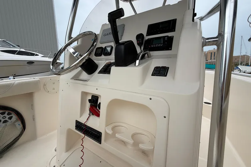 Slide: The Image of 2008 Pursuit C 230 Center Console boat dashboard with steering wheel and controls. - 28