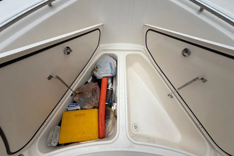 Slide: The Image of Storage compartments on a 2008 Pursuit C 230 Center Console boat, containing various items. - 31