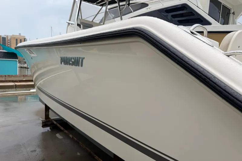Slide: The Image of 2008 Pursuit C 230 Center Console boat docked, showcasing sleek design and branding. - 35