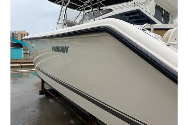 Slide: The Image of 2008 Pursuit C 230 Center Console boat docked, showcasing sleek design and branding. - 37