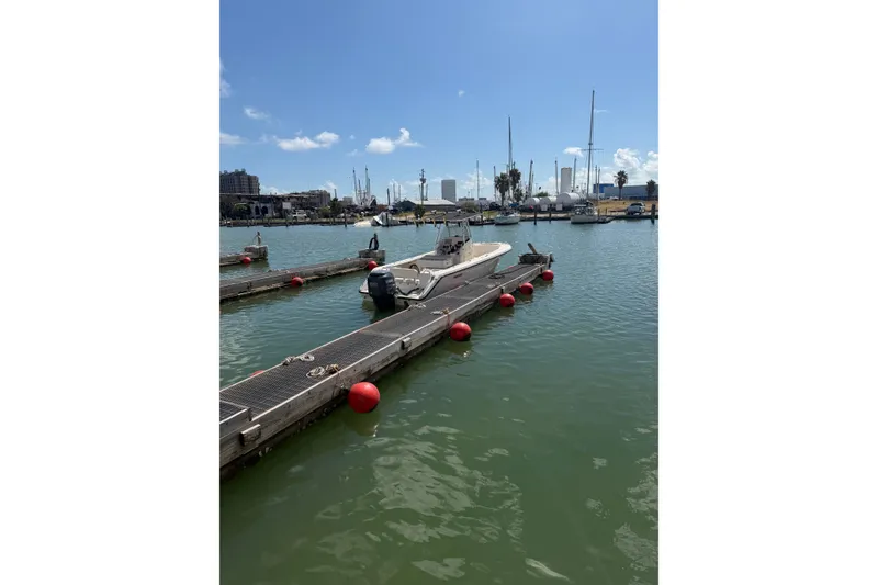 Slide: The Image of 2008 Pursuit C 230 Center Console boat docked in a sunny marina. - 58