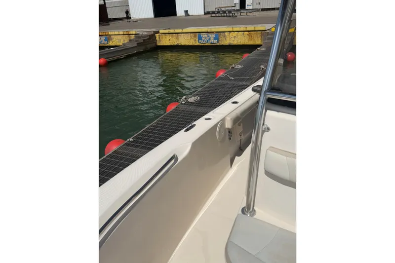 Slide: The Image of 2008 Pursuit C 230 Center Console boat docked at marina with safety rail. - 48