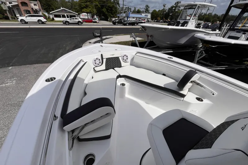 Slide: The Image of 2026 Tidewater 210 LXF boat interior with seating and speakers, displayed outdoors. - 11