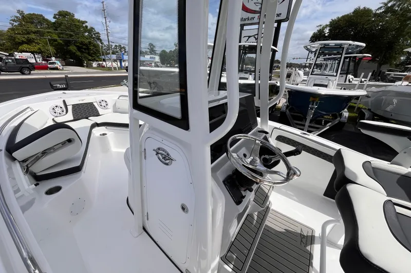 Slide: The Image of 2026 Tidewater 210 LXF boat interior with steering wheel and seating area. - 12