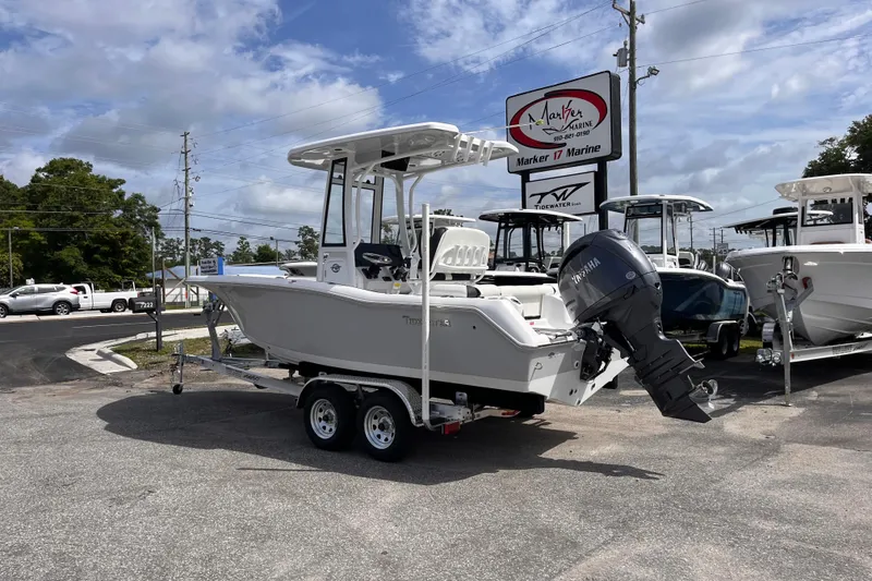 Slide: The Image of 2026 Tidewater 210 LXF boat on trailer at marine dealership. - 2