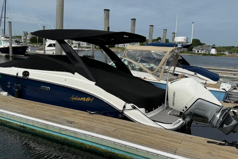Slide: The Image of 2023 Sea Ray SLX 260 Outboard docked with black cover. - 2