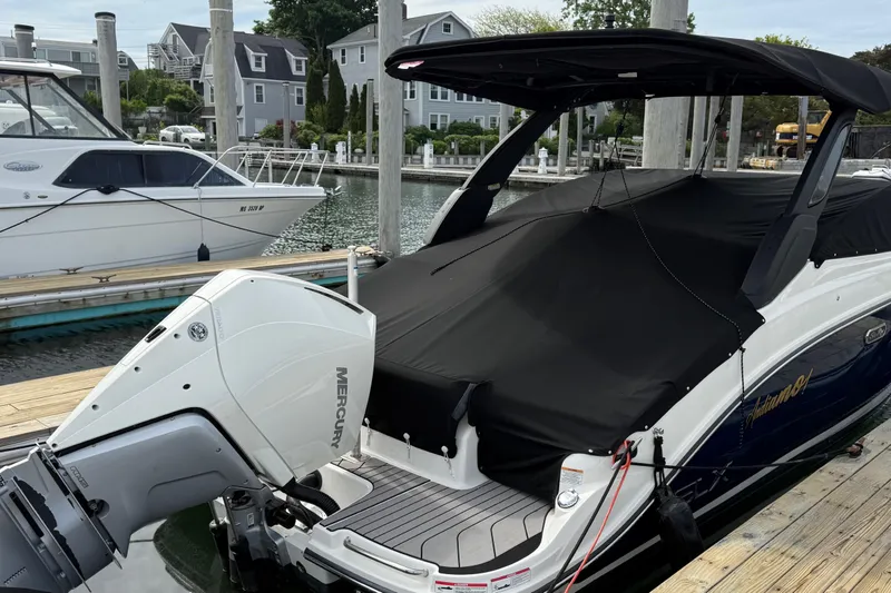 Slide: The Image of 2023 Sea Ray SLX 260 Outboard boat docked with black cover and Mercury engine. - 32