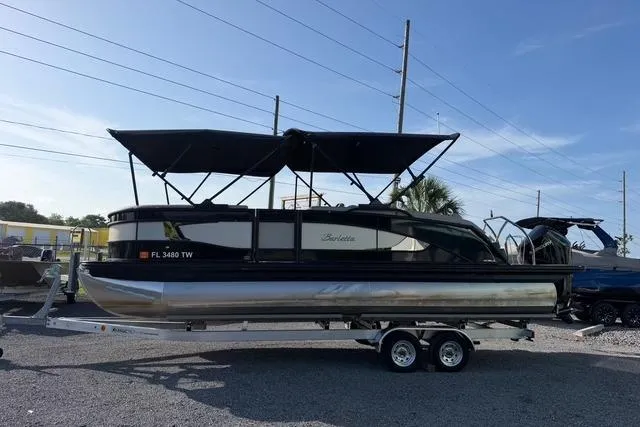 Slide: The Image of 2023 Barletta L23U pontoon boat on trailer, featuring dual bimini tops. - 2