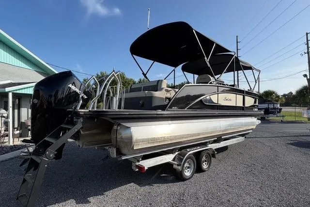 Slide: The Image of 2023 Barletta L23U pontoon boat on trailer, featuring a sleek design and powerful engine. - 6