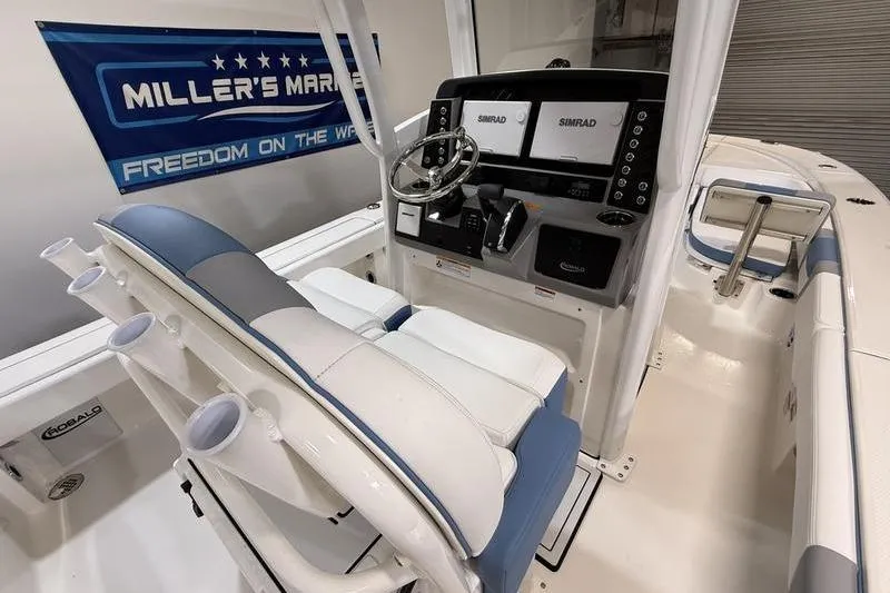 Slide: The Image of 2026 Robalo 246 Cayman boat interior with helm, dual Simrad displays, and seating. - 16