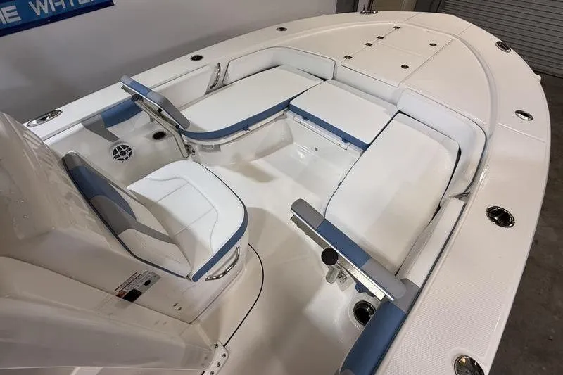 Slide: The Image of 2026 Robalo 246 Cayman boat interior with white and blue seating, spacious layout. - 21