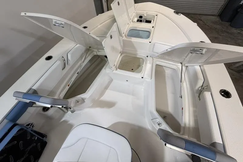 Slide: The Image of 2026 Robalo 246 Cayman boat interior with open storage compartments and seating. - 22