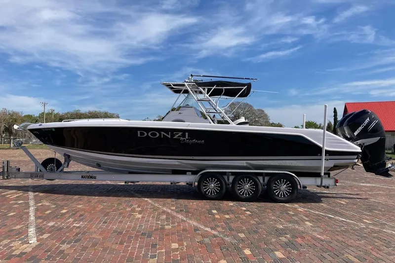 Slide: The Image of 2005 Donzi 35 ZF Daytona boat on trailer, black and white design, parked on brick pavement. - 1