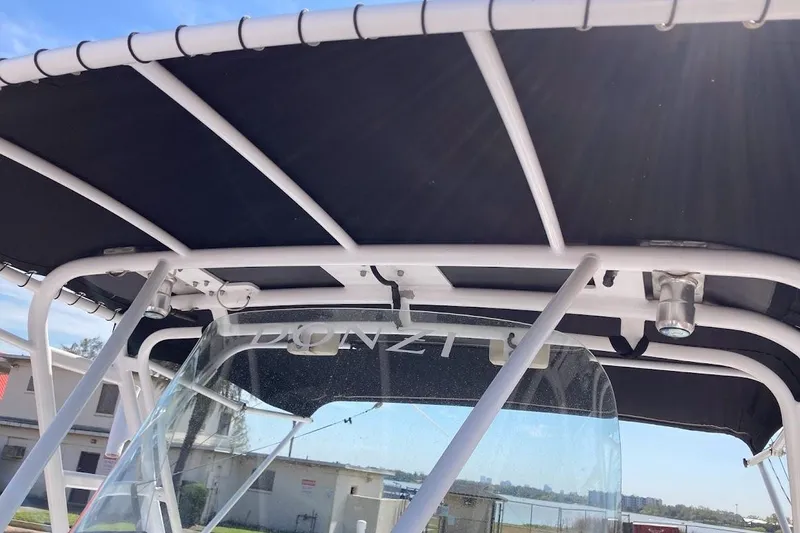 Slide: The Image of 2005 Donzi 35 ZF Daytona boat with T-top and windshield, docked under clear sky. - 24