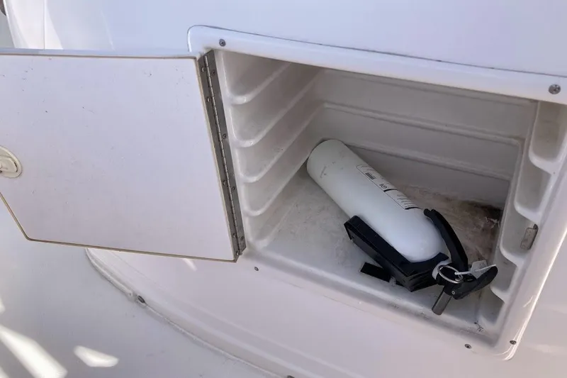 Slide: The Image of Open storage compartment on 2005 Donzi 35 ZF Daytona boat with fire extinguisher inside. - 26