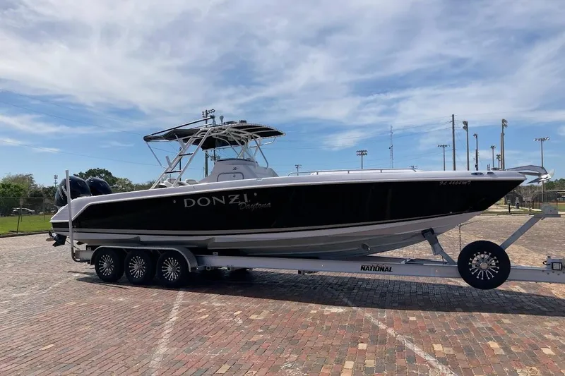 Slide: The Image of 2005 Donzi 35 ZF Daytona boat on trailer, parked on brick pavement under blue sky. - 3