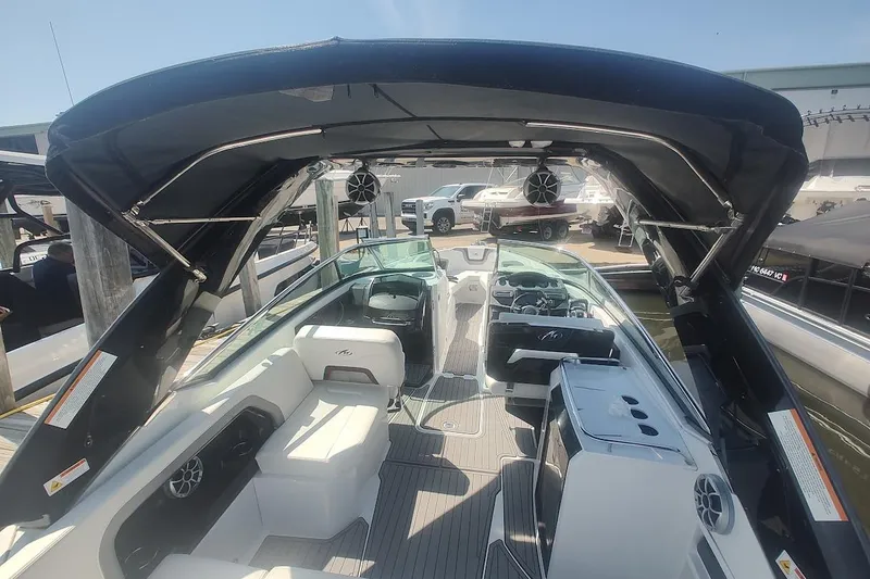 Slide: The Image of 2017 Monterey 298SS Super Sport boat interior with seating and canopy at a marina. - 9