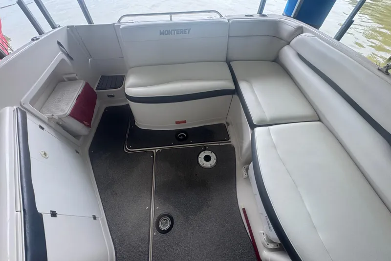 Slide: The Image of 2005 Monterey 248LS Montura Bowrider interior with white seating and storage compartments. - 12