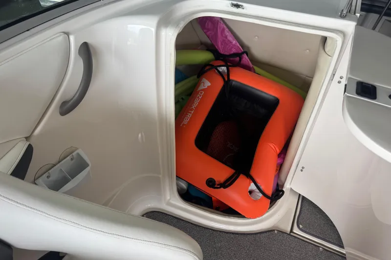 Slide: The Image of Storage compartment in a 2005 Monterey 248LS Montura Bowrider with life jackets and pool noodles. - 15