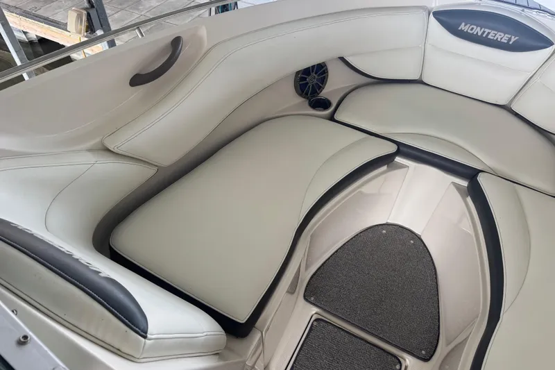 Slide: The Image of 2005 Monterey 248LS Montura Bowrider interior with white cushioned seating and speaker. - 18