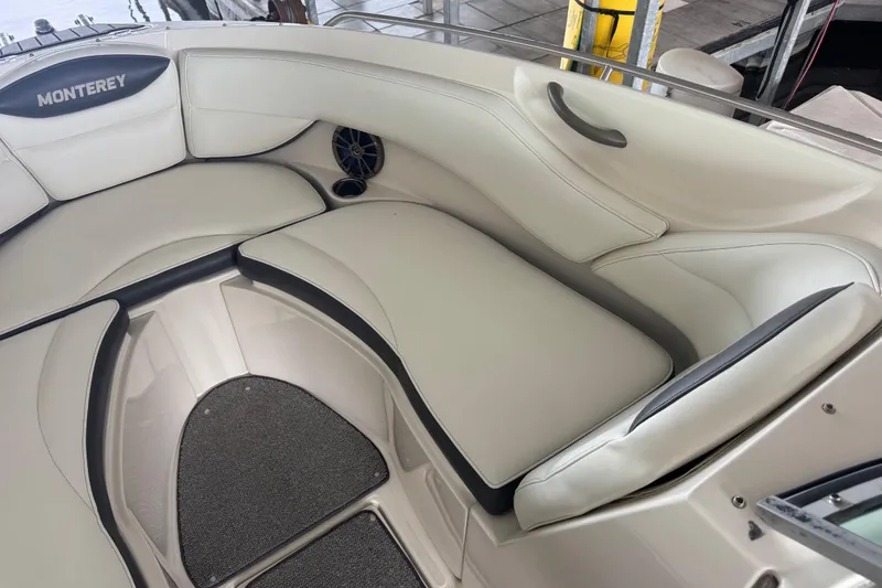 Slide: The Image of 2005 Monterey 248LS Montura Bowrider interior with white cushioned seating and speaker. - 19