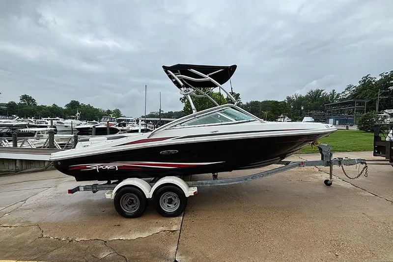 The Image of 2011 Sea Ray 205 Sport boat on trailer at marina, overcast sky. - 0