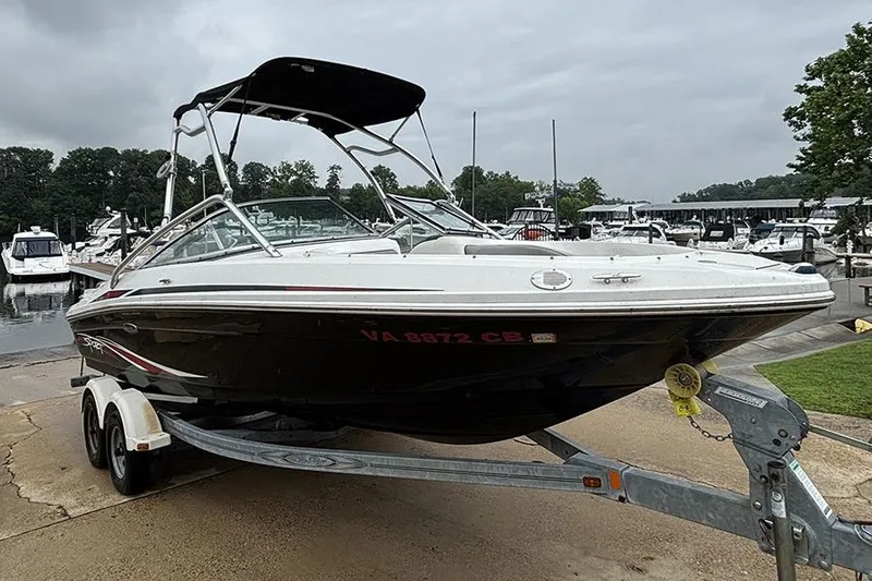 Slide: The Image of 2011 Sea Ray 205 Sport boat on trailer at marina, overcast sky. - 1