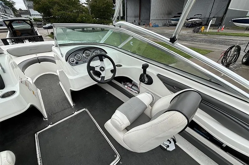 Slide: The Image of Interior view of a 2011 Sea Ray 205 Sport boat, featuring steering wheel and seating. - 11