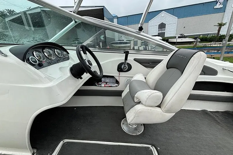 Slide: The Image of Interior of a 2011 Sea Ray 205 Sport boat, featuring steering wheel and captain's chair. - 12