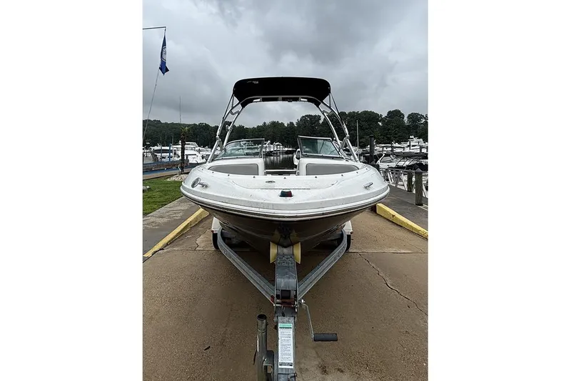 Slide: The Image of 2011 Sea Ray 205 Sport boat on trailer at marina, cloudy sky background. - 2