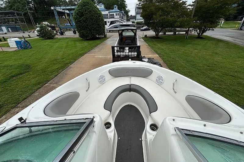 Slide: The Image of 2011 Sea Ray 205 Sport boat on trailer, parked on a driveway with green lawn. - 20