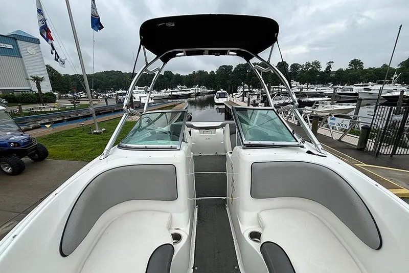 Slide: The Image of 2011 Sea Ray 205 Sport boat docked at marina, featuring spacious seating and sleek design. - 22