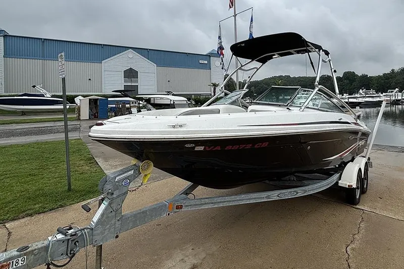 Slide: The Image of 2011 Sea Ray 205 Sport boat on trailer, parked near marina. - 3