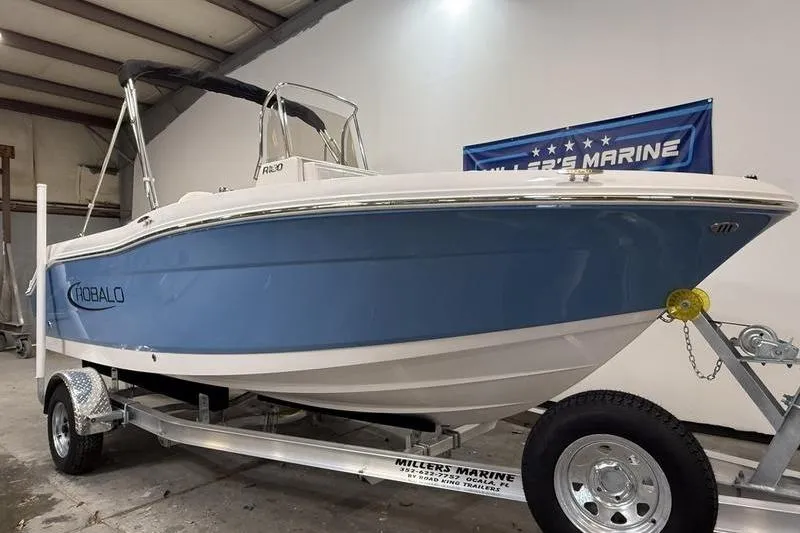 Slide: The Image of 2026 Robalo R180 Center Console boat on trailer in warehouse. - 1