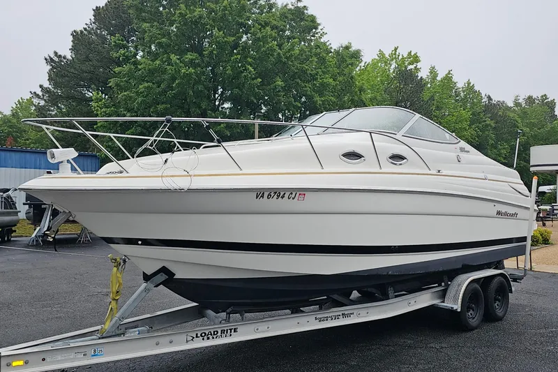 The Image of 2002 Wellcraft 2600 Martinique boat on trailer outdoors. - 1