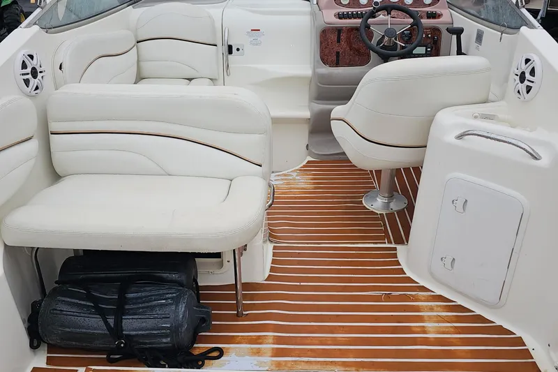 Slide: The Image of 2002 Wellcraft 2600 Martinique boat interior with white seating and wood-patterned flooring. - 10