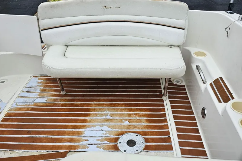 Slide: The Image of 2002 Wellcraft 2600 Martinique boat interior with white seating and wooden deck flooring. - 19