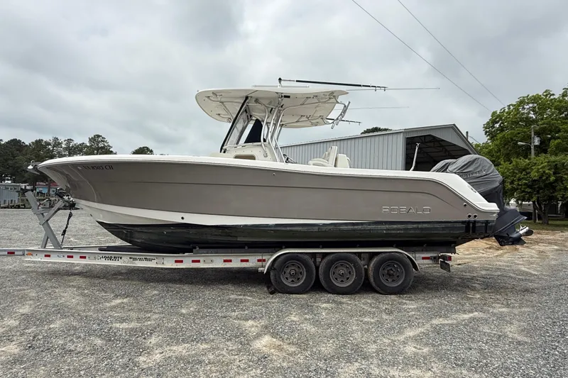 The Image of 2008 Robalo R300 Center Console boat on trailer, parked outdoors. - 0