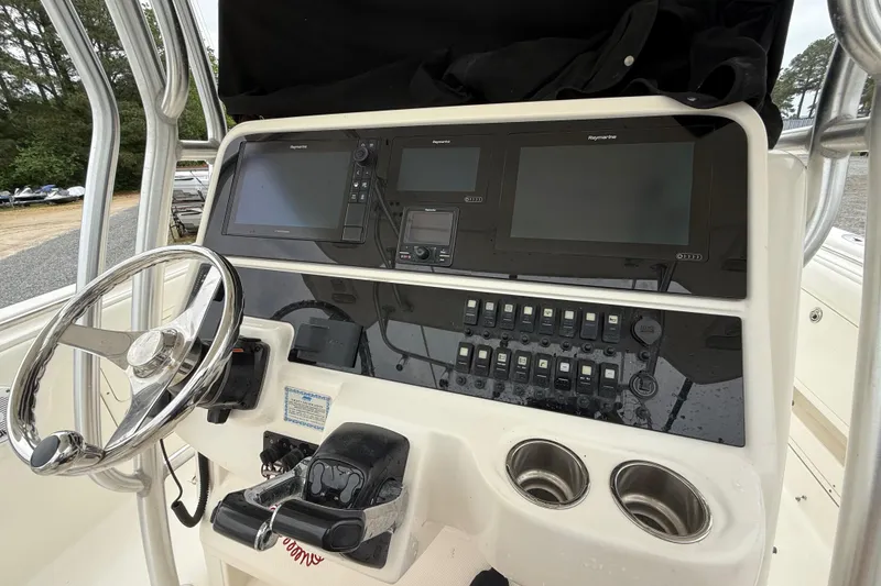 Slide: The Image of 2008 Robalo R300 Center Console boat dashboard with steering wheel and electronic controls. - 11